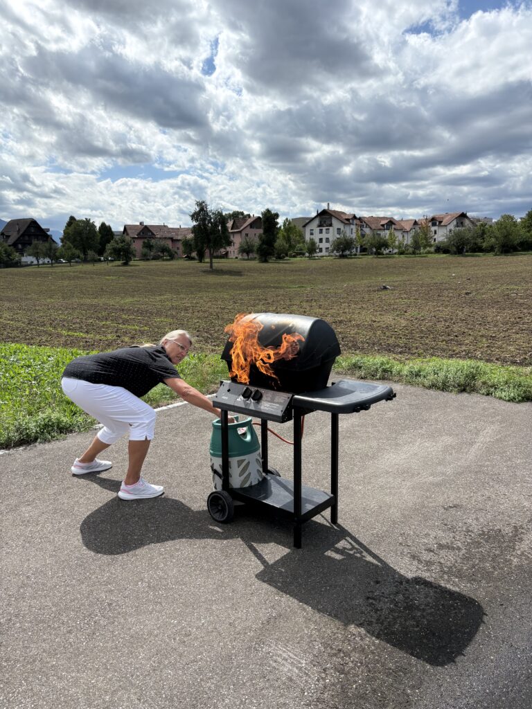 eilnehmerin bei einer praktischen Brandschutzübung an einem kontrolliert brennenden Gasgrill